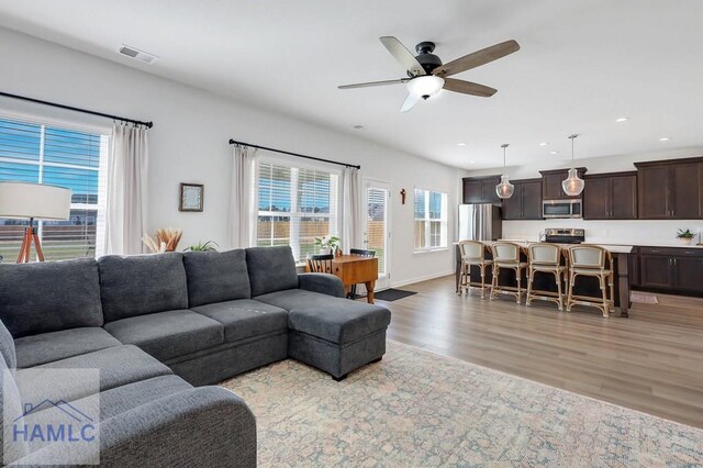 kitchen featuring a wealth of natural light, stainless steel dishwasher, light countertops, and a sink