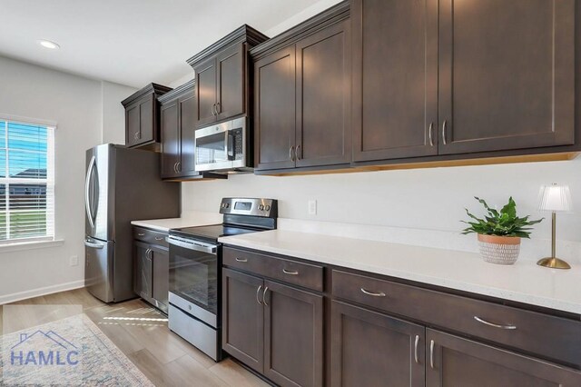 dining area featuring wood finished floors, a decorative wall, wainscoting, and an inviting chandelier