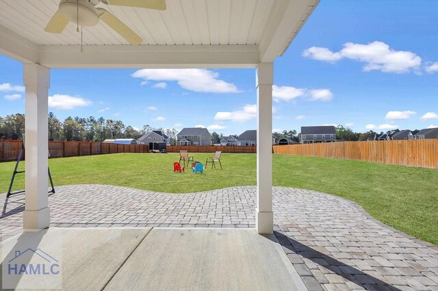 back of property featuring a lawn, fence, a patio area, and a ceiling fan
