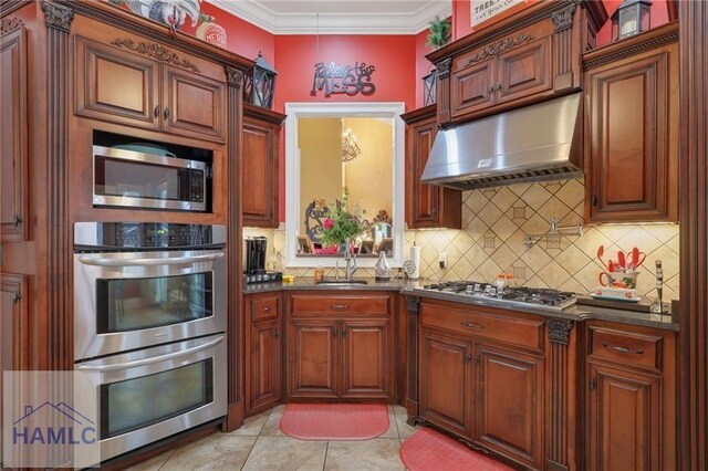 655 Littlefield St, Jesup, GA 31546 - kitchen featuring a sink, stainless steel appliances, ornamental molding, under cabinet range hood, and backsplash
