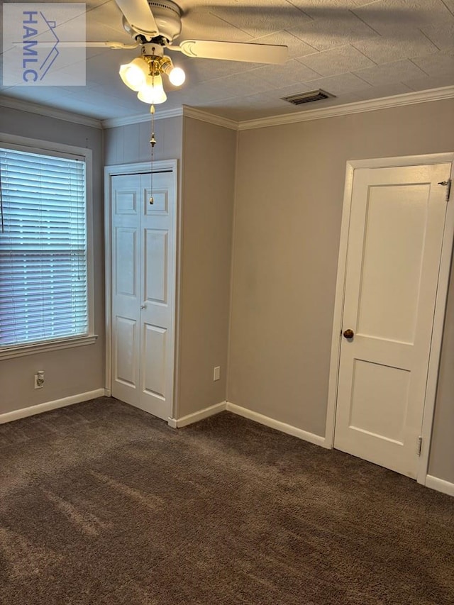 carpeted empty room featuring ceiling fan and crown molding