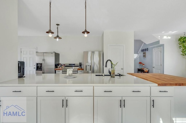 kitchen featuring white cabinetry, pendant lighting, stainless steel appliances, and sink