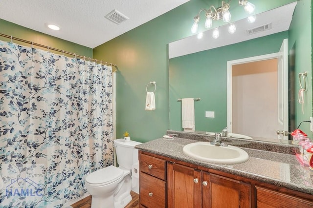 bathroom featuring a shower with curtain, vanity, a textured ceiling, hardwood / wood-style flooring, and toilet