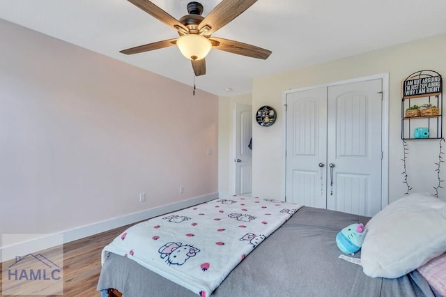 bedroom featuring hardwood / wood-style flooring, ceiling fan, and a closet