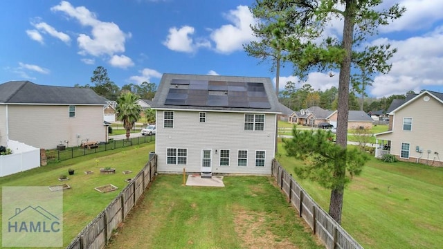 rear view of property with a patio area, a yard, central AC unit, and solar panels