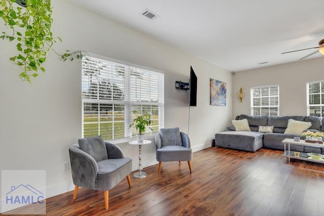 living room featuring ceiling fan and dark wood-type flooring