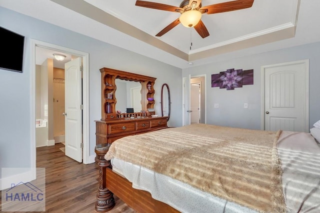 bedroom featuring hardwood / wood-style flooring, ceiling fan, a raised ceiling, and ornamental molding