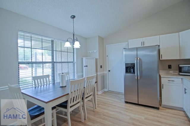776 Madison Dr, Hinesville, GA 31313 - dining area with a chandelier, plenty of natural light, light wood-style floors, vaulted ceiling, and a textured ceiling