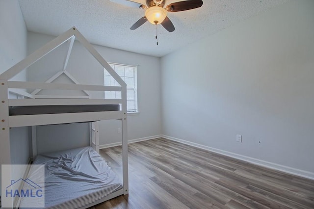776 Madison Dr, Hinesville, GA 31313 - unfurnished bedroom with wood finished floors, a textured ceiling, baseboards, and ceiling fan