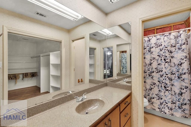 bathroom featuring vanity, toilet, wood-type flooring, and walk in shower