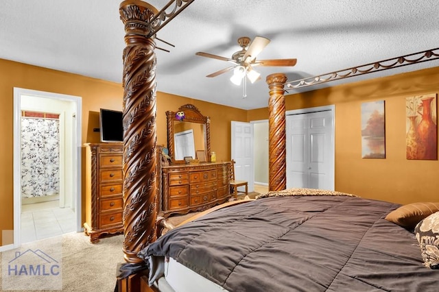 bedroom featuring ensuite bath, a textured ceiling, light colored carpet, ceiling fan, and a closet