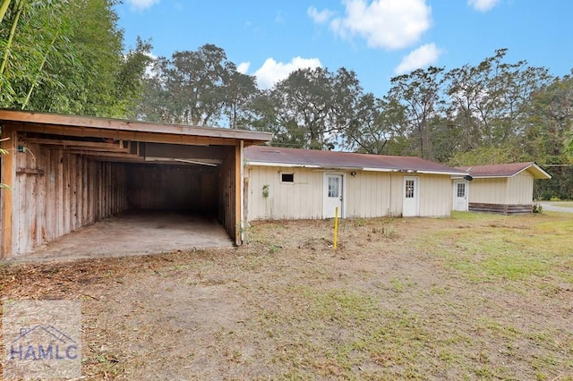 back of house featuring a carport