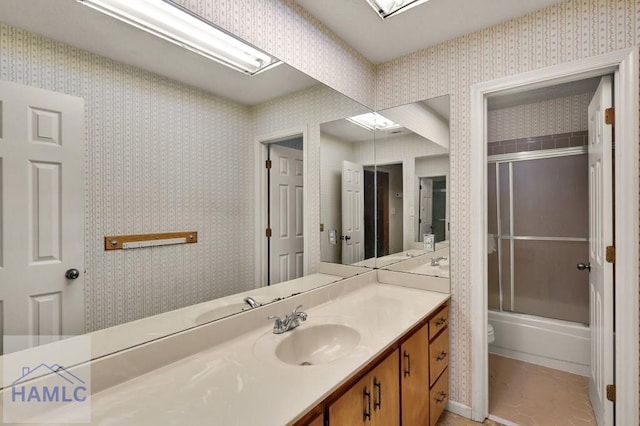 full bathroom featuring vanity, toilet, and bath / shower combo with glass door