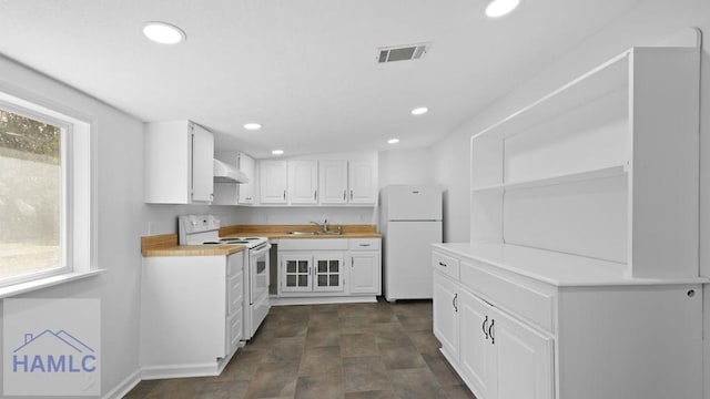 kitchen featuring wood counters, white appliances, plenty of natural light, and white cabinets