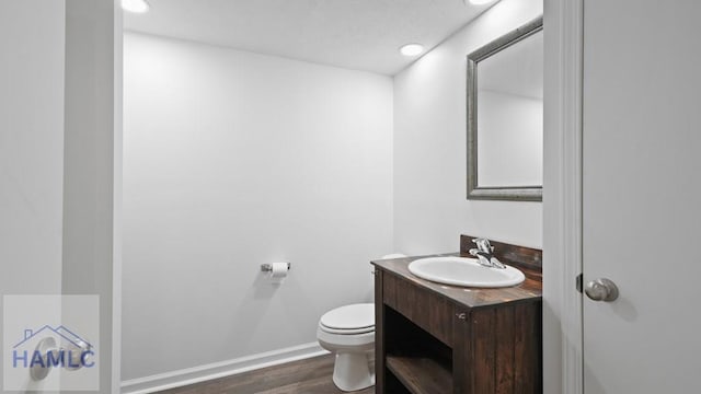 bathroom featuring vanity, hardwood / wood-style floors, and toilet