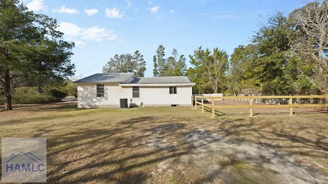 rear view of house featuring a yard and central AC