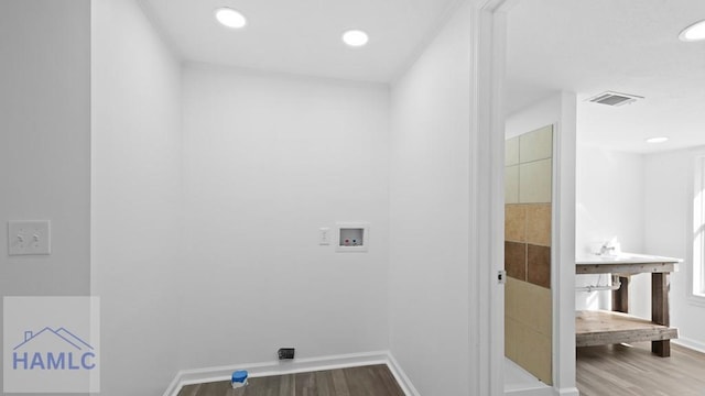 clothes washing area featuring hardwood / wood-style flooring and hookup for a washing machine