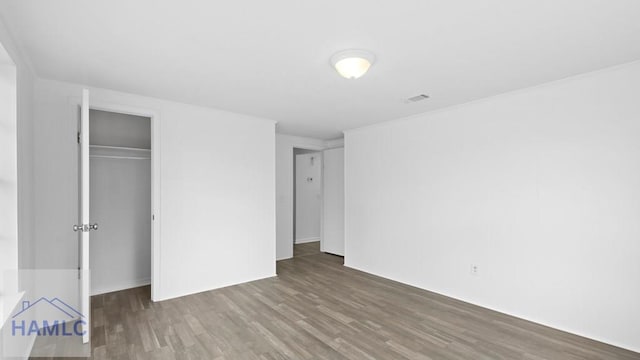 unfurnished bedroom with wood-type flooring and a closet