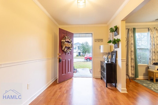 foyer entrance featuring light wood finished floors, baseboards, and ornamental molding