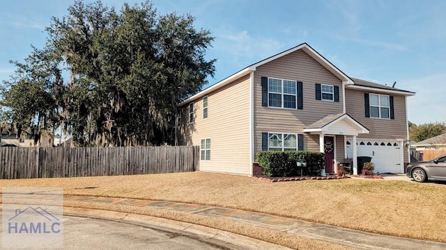 view of property featuring a garage and a front lawn