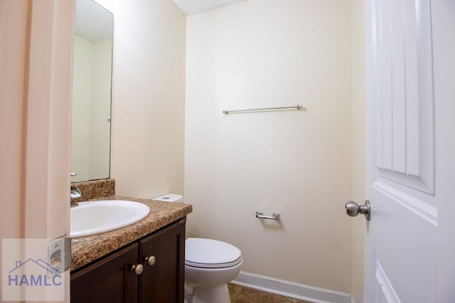 bathroom featuring baseboards, vanity, toilet, and tile patterned floors