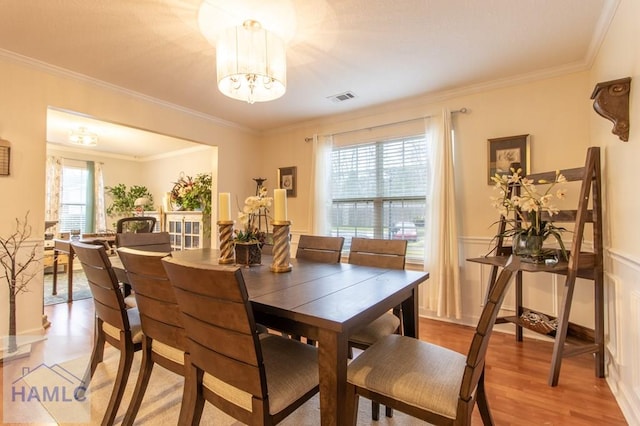 dining room featuring a chandelier, plenty of natural light, wood finished floors, and visible vents