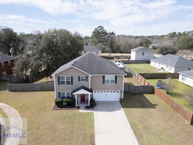 traditional home with fence private yard, concrete driveway, an attached garage, and a front yard