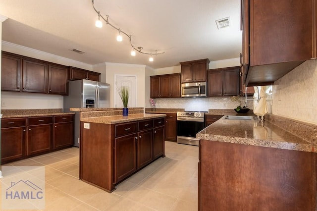 kitchen featuring visible vents, a kitchen island, appliances with stainless steel finishes, crown molding, and dark brown cabinets