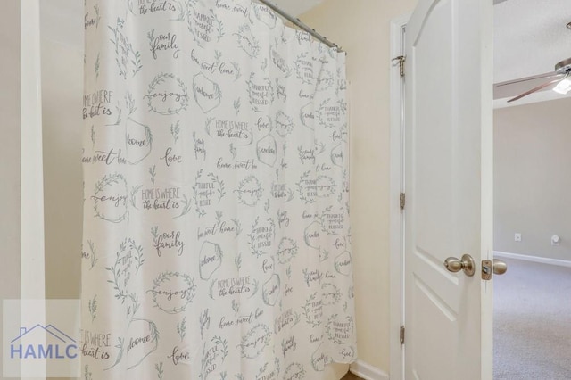 bathroom with ceiling fan and curtained shower