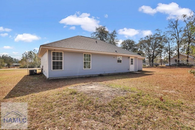 back of property featuring central AC unit and a lawn