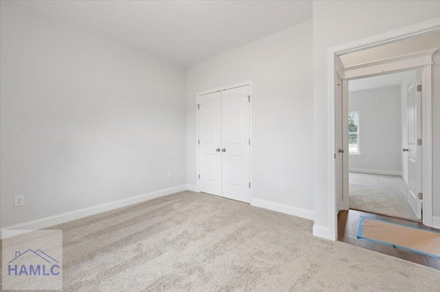 unfurnished bedroom featuring a closet, baseboards, and carpet flooring