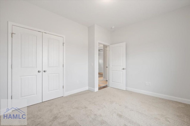 unfurnished bedroom featuring a closet, carpet flooring, and baseboards