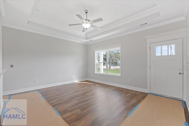 entrance foyer featuring a tray ceiling, wood finished floors, visible vents, and ceiling fan