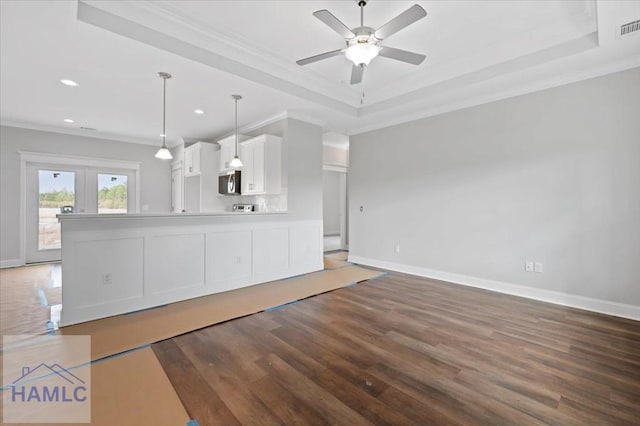 unfurnished living room with visible vents, crown molding, ceiling fan, wood finished floors, and a raised ceiling