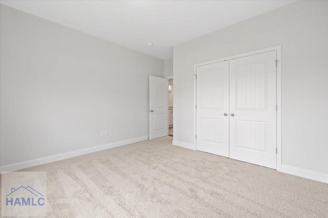 unfurnished bedroom with a closet, carpet floors, and baseboards