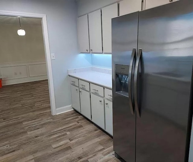 kitchen featuring decorative light fixtures, white cabinetry, stainless steel refrigerator with ice dispenser, and light hardwood / wood-style flooring