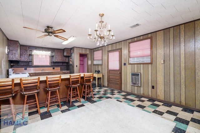 401E Smith St, Claxton, GA 30417 - kitchen with tile patterned floors, white range with electric stovetop, heating unit, a chandelier, and wooden walls