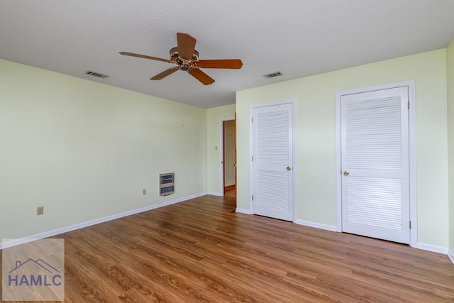 401E Smith St, Claxton, GA 30417 - unfurnished bedroom with two closets, wood finished floors, and ceiling fan