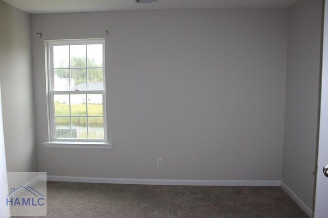 unfurnished room featuring dark carpet