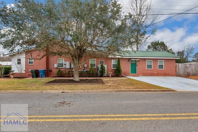 ranch-style home with brick siding, fence, and a front lawn