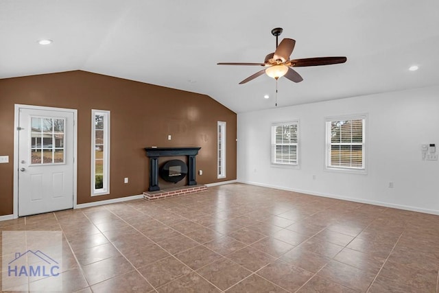 unfurnished living room with a ceiling fan, lofted ceiling, a brick fireplace, and tile patterned flooring