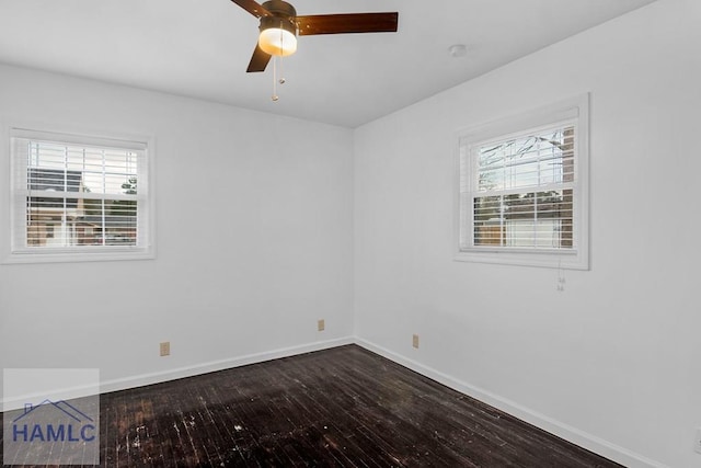 unfurnished room with ceiling fan, dark wood finished floors, and baseboards