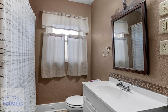 bathroom with toilet, a textured wall, vanity, and a shower with curtain