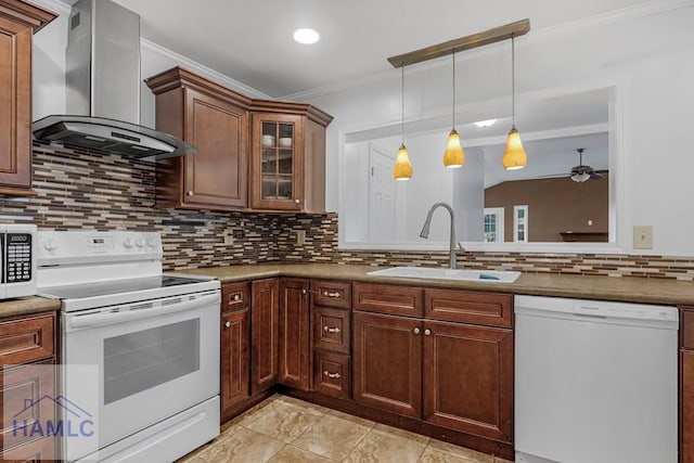 kitchen featuring decorative light fixtures, ornamental molding, a sink, wall chimney range hood, and white appliances