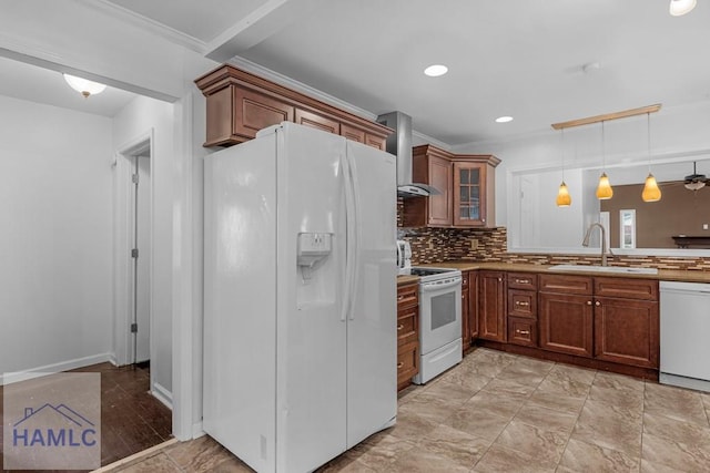 kitchen featuring white appliances, decorative backsplash, wall chimney exhaust hood, crown molding, and a sink