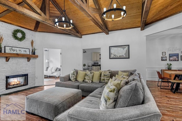 living area with a fireplace, a notable chandelier, wood ceiling, wood finished floors, and beamed ceiling