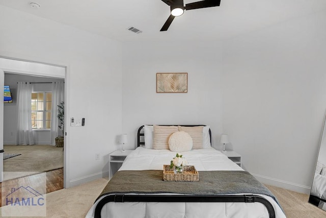 bedroom featuring baseboards, visible vents, and light colored carpet