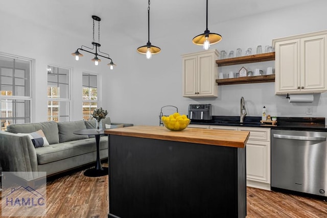 kitchen with wood finished floors, a sink, wooden counters, dishwasher, and pendant lighting