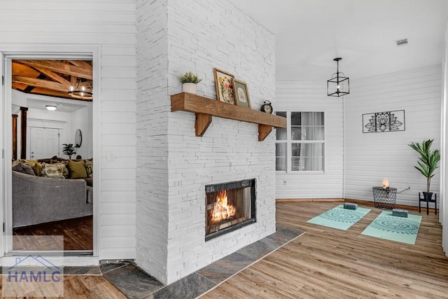 unfurnished living room with visible vents, a fireplace, and wood finished floors