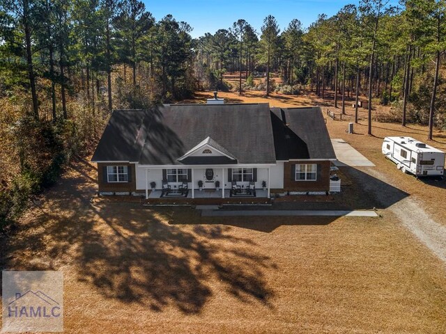 back of property with driveway and a porch